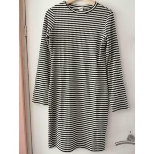Stapeltje dameskleding: broek, shirts, jurkje