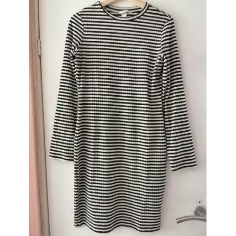 Stapeltje dameskleding: broek, shirts, jurkje
