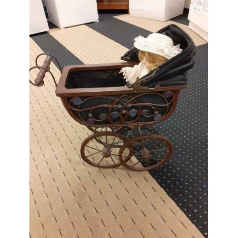 Antieke kinderwagen met pop