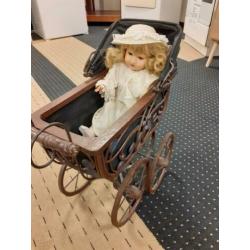 Antieke kinderwagen met pop
