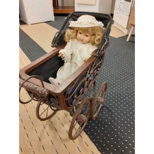 Antieke kinderwagen met pop