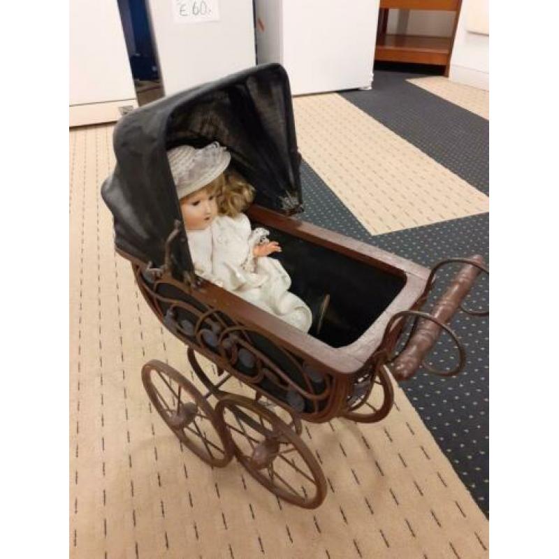 Antieke kinderwagen met pop