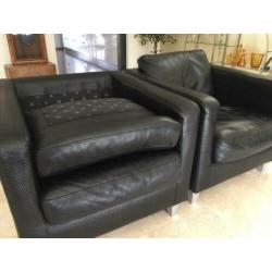 2 Machalke fauteuils van zwart gevlochten leer.